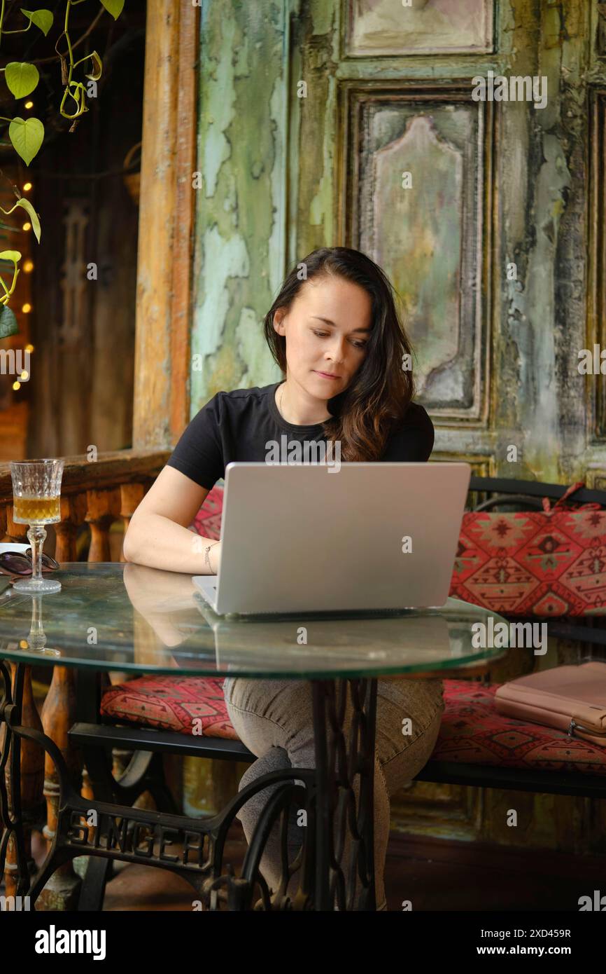 Une blogueuse spécialisée dans la nourriture de voyage décrit ses impressions sur un blog en ligne, en visitant des cafés et des bars dans la ville où elle est arrivée Banque D'Images