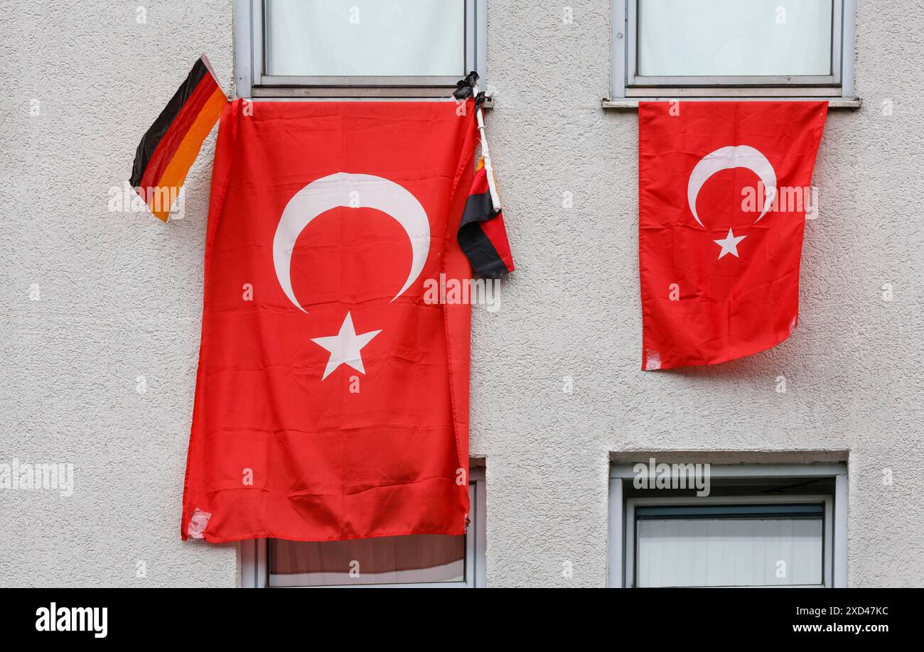 Deux drapeaux turcs et un petit drapeau allemand accrochés aux fenêtres d'une maison pendant le Championnat d'Europe de football, Berlin, 19 juin 2024 Banque D'Images