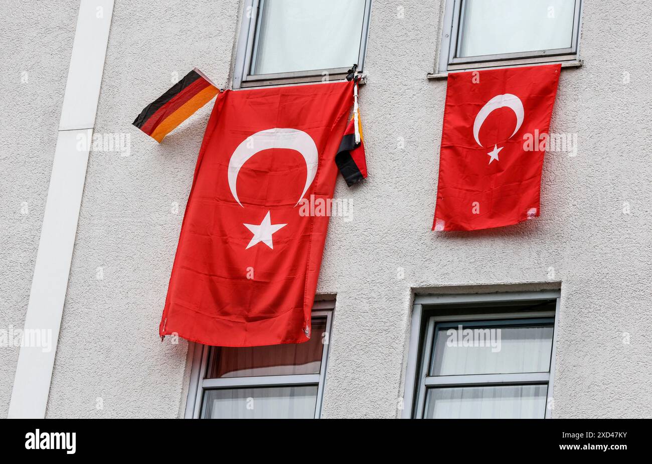 Deux drapeaux turcs et un petit drapeau allemand accrochés aux fenêtres d'une maison pendant le Championnat d'Europe de football, Berlin, 19 juin 2024 Banque D'Images