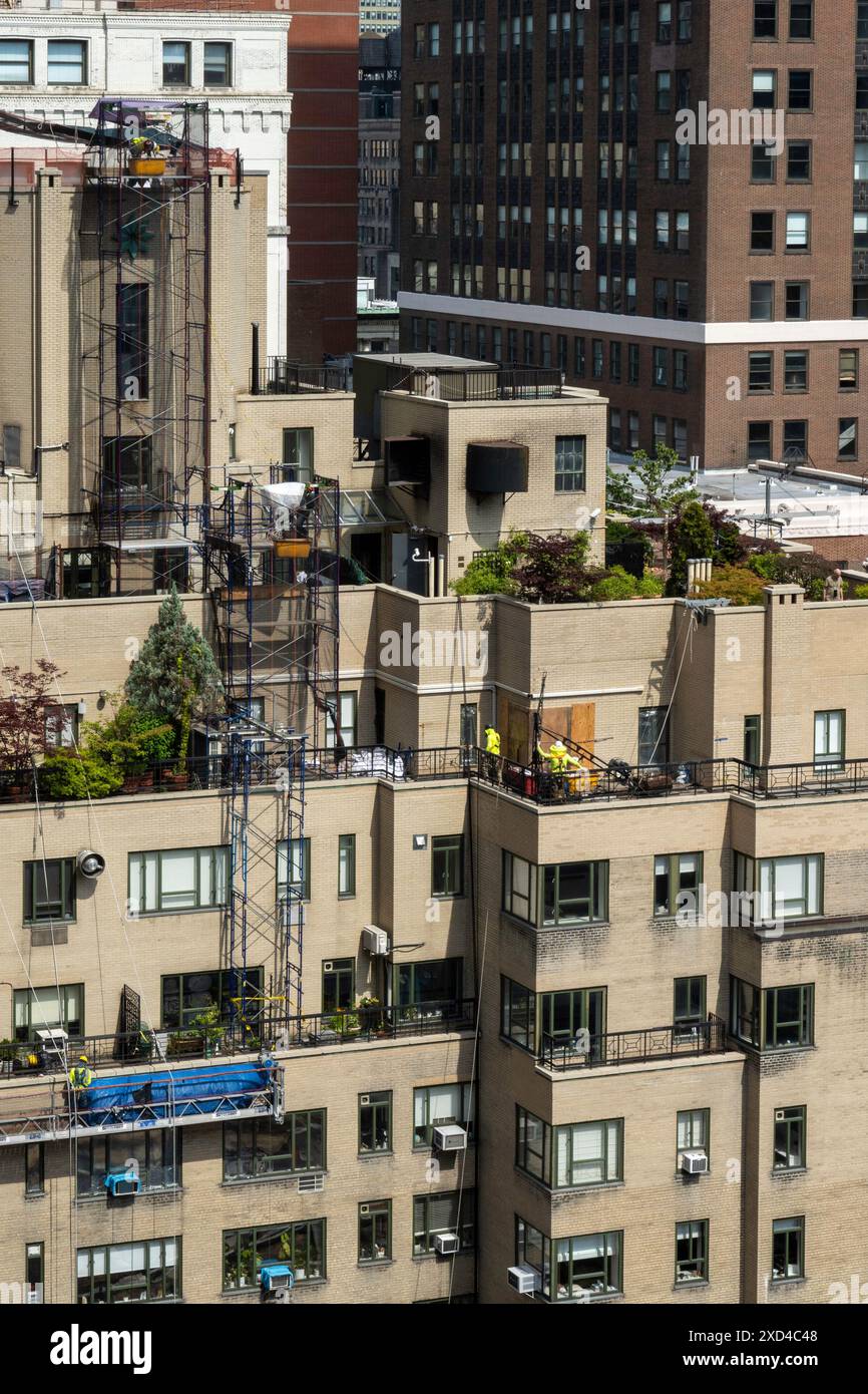 Ouvriers de la construction sur un immeuble d'appartements à New York dans un panier suspendu, Midtown Manhattan, États-Unis 2024 Banque D'Images