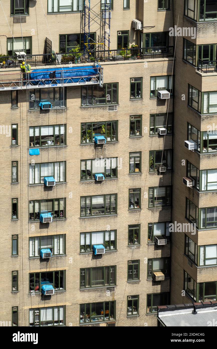 Ouvriers de la construction sur un immeuble d'appartements à New York dans un panier suspendu, Midtown Manhattan, États-Unis 2024 Banque D'Images
