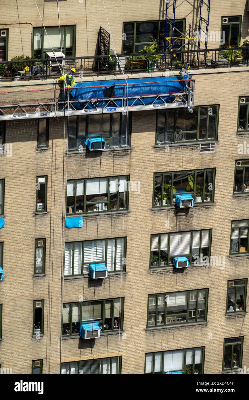 Ouvriers de la construction sur un immeuble d'appartements à New York dans un panier suspendu, Midtown Manhattan, États-Unis 2024 Banque D'Images