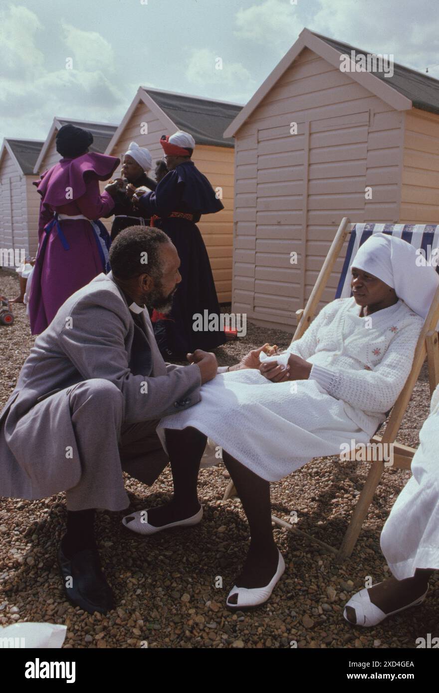 Mount Sion Spiritual Baptist Church, une sortie annuelle de l'église à Felixstowe, un nouveau membre de l'église reçoit des paroles de louanges et de conseils d'un pasteur principal. Elle a été baptisée par immersion totale n'ayant jamais été au bord de la mer ou vu la mer auparavant, elle est sous le choc. Felixstowe, Suffolk, Angleterre des années 1990 1990 Royaume-Uni HOMER SYKES Banque D'Images