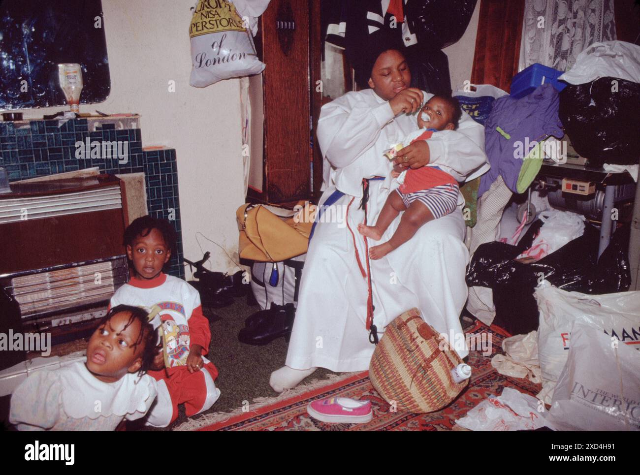 La mère et le bébé se nourrissent dans la crèche à l'étage de l'église baptiste spirituelle Mount Sion. Cette chambre à l'étage dans l'église est utilisé une pépinière et un espace de stockage pour les vêtements etc qui iront à la charité. Kensal Green, Londres, Angleterre des années 1990 1990 Royaume-Uni HOMER SYKES Banque D'Images