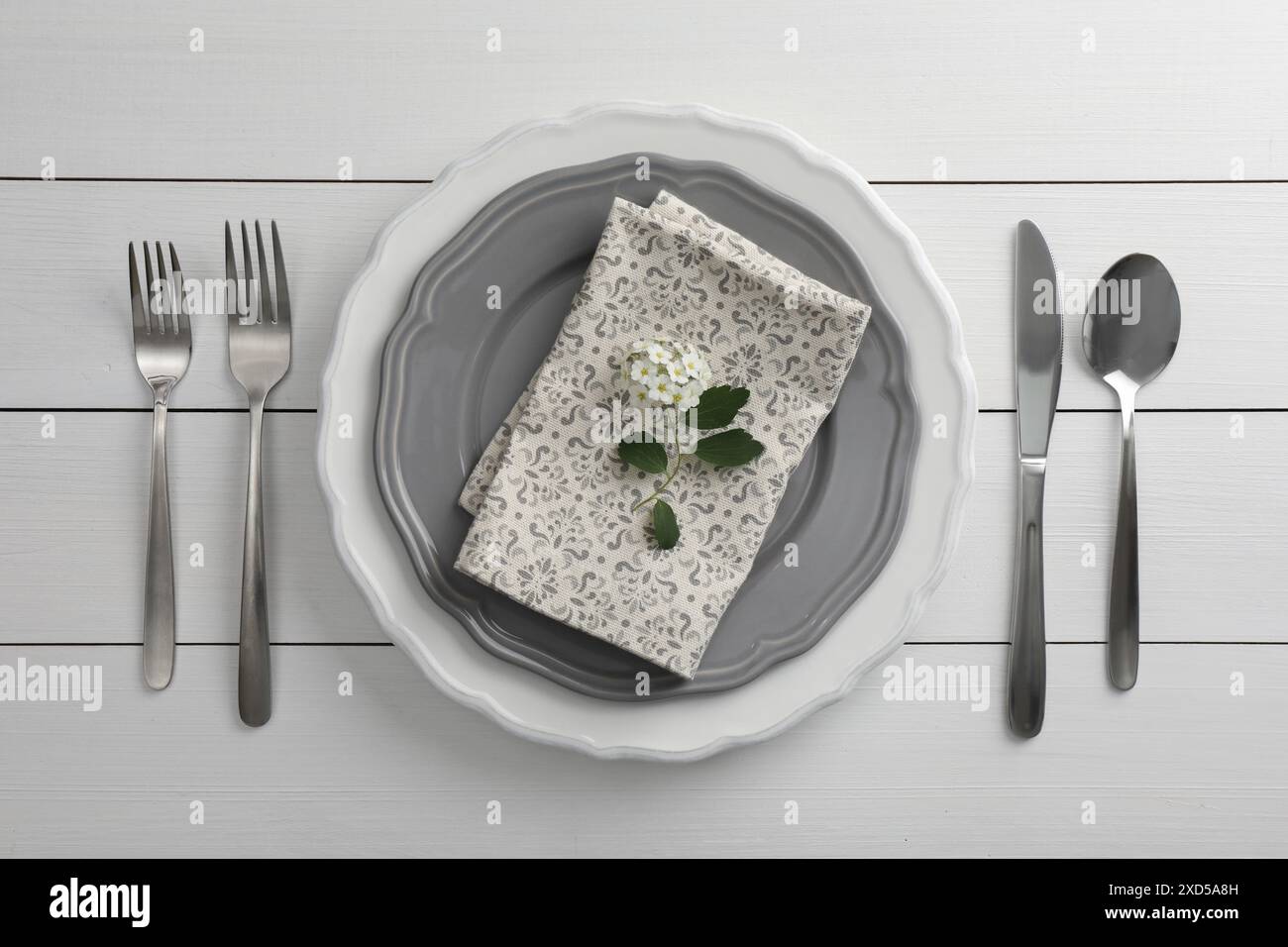 Cadre élégant avec couverts et assiettes sur table en bois blanc, pose à plat Banque D'Images