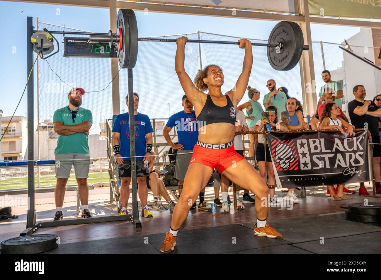 Participants soulevant des poids lourds lors d'une compétition de cross fit à Sevilla, España. L'événement met en valeur la force, la détermination et l'athlétisme. Banque D'Images