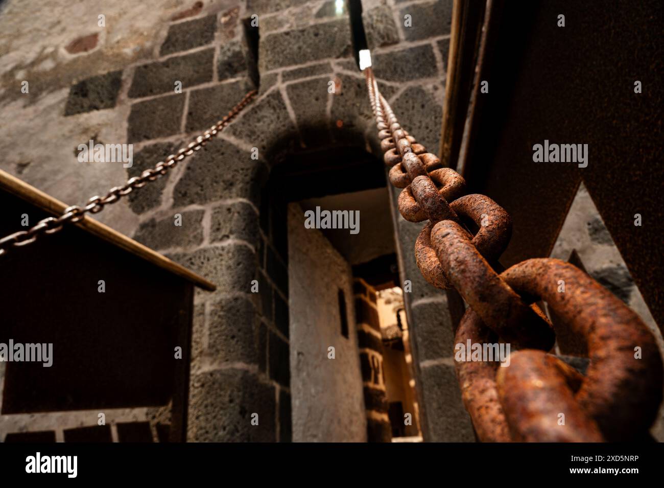 Une chaîne est suspendue au plafond d'une pièce. La chaîne est rouillée et il est vieux Banque D'Images