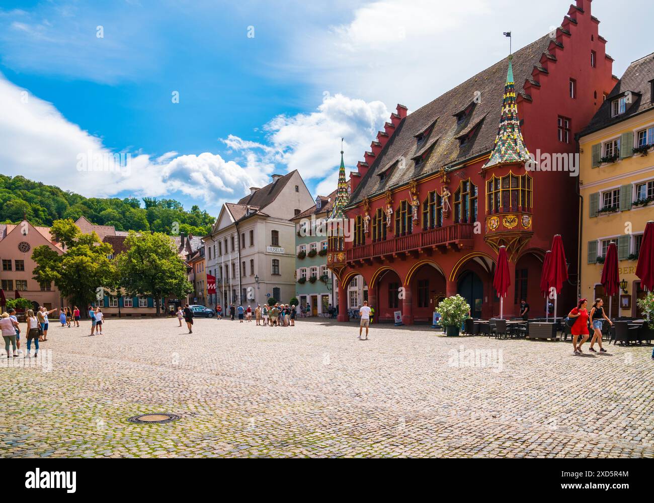 Freiburg im Breisgau, Allemagne, 23 juillet 2023, maisons anciennes historiques et bâtiment rouge historisches kaufhaus à muenster cathédrale place pavée dans Banque D'Images