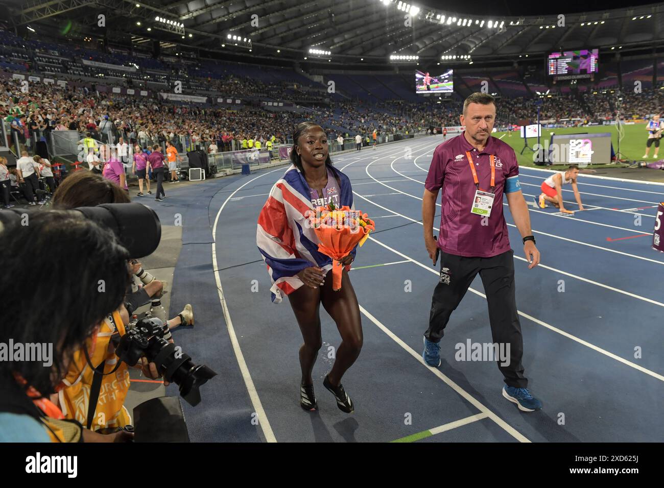 Desiree Henry de Grande-Bretagne escortée sur la piste par un officiel après avoir remporté la finale du relais féminin du 100 m au Championnat d’Europe d’athlétisme Banque D'Images