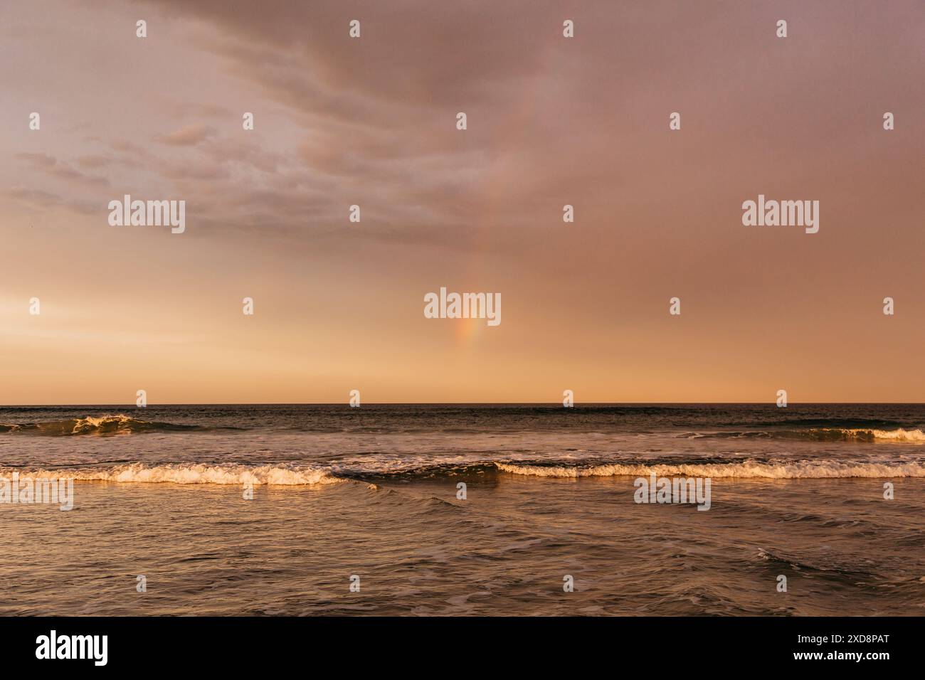 Ponce Inlet, Floride vagues un jour nuageux avec un arc-en-ciel Banque D'Images