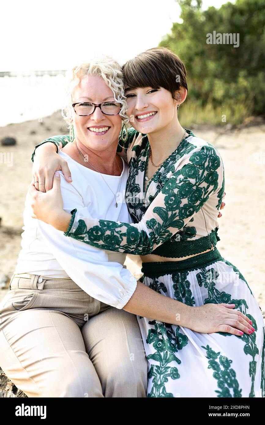 Deux femmes embrassant et souriant à la caméra, à l'extérieur près de th Banque D'Images