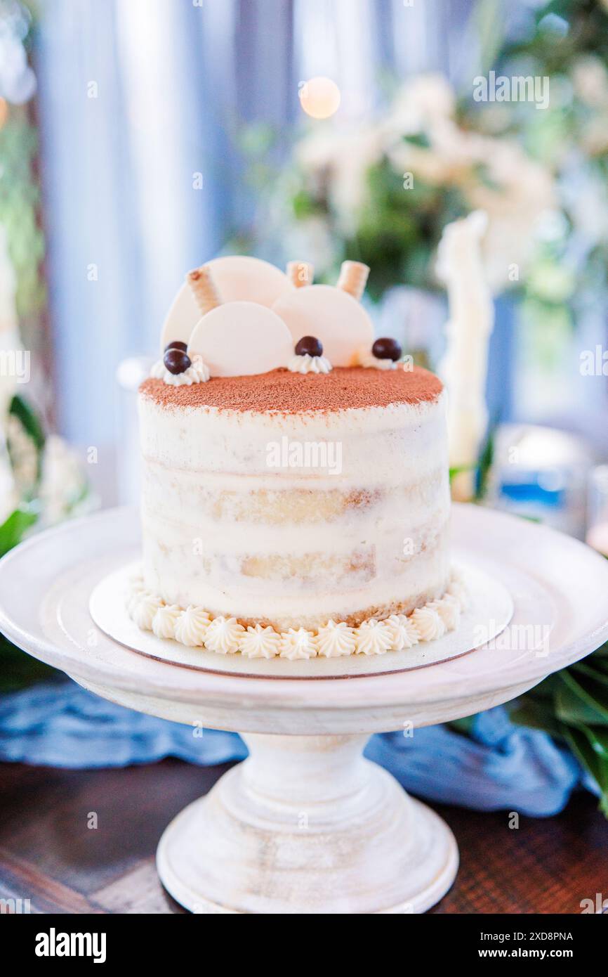 Elégant gâteau superposé avec glaçage léger et garnitures sur un stand Banque D'Images
