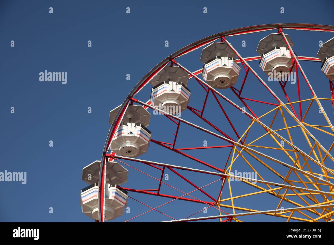 Grande roue contre un ciel bleu clair dans un parc d'attractions. Banque D'Images
