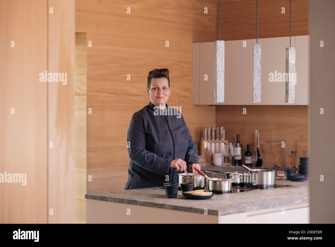Chef dans une cuisine moderne en bois au design minimaliste Banque D'Images