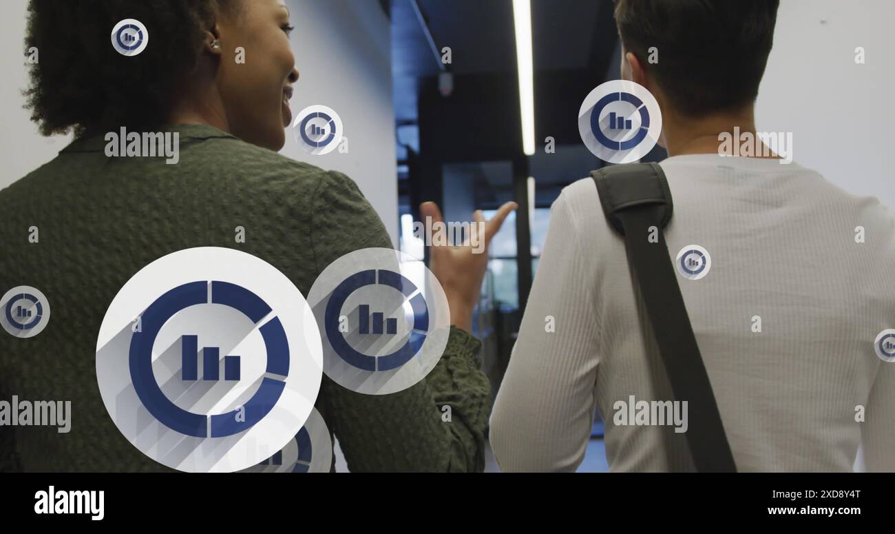 Image de plusieurs icônes de graphique à barres flottant contre deux femmes diverses discutant au bureau Banque D'Images