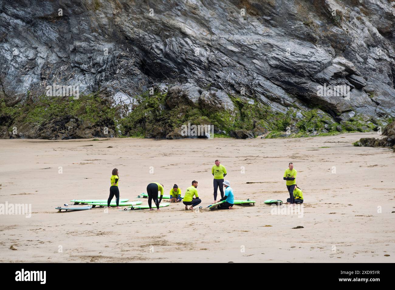 Un instructeur de surf de l'Escape Surf School avec des apprenants novices de surf au début d'une leçon de surf sur Towan Beach à Newquay en Cornouailles. Banque D'Images