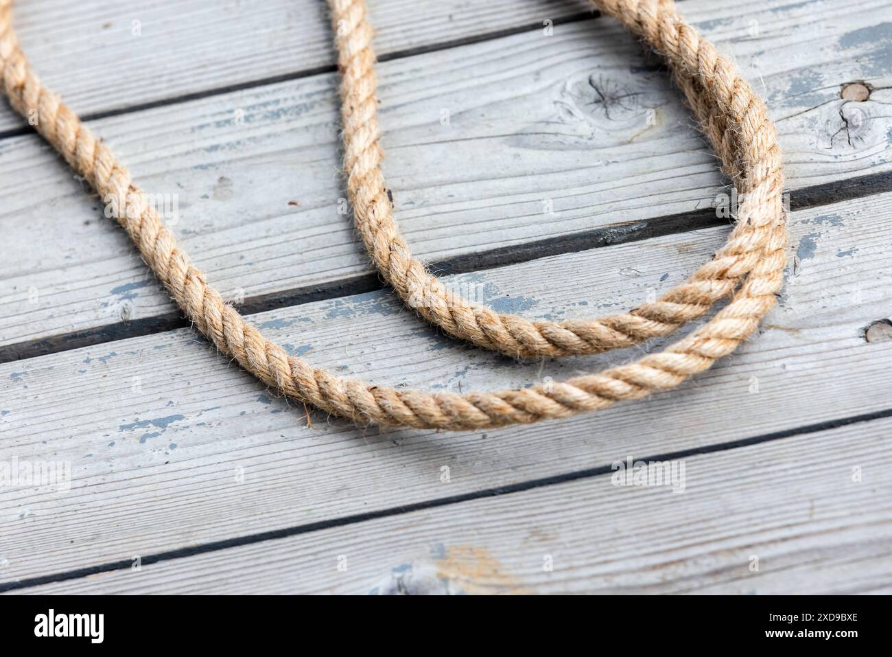 La corde nautique repose sur le pont de navires en bois altéré Banque D'Images
