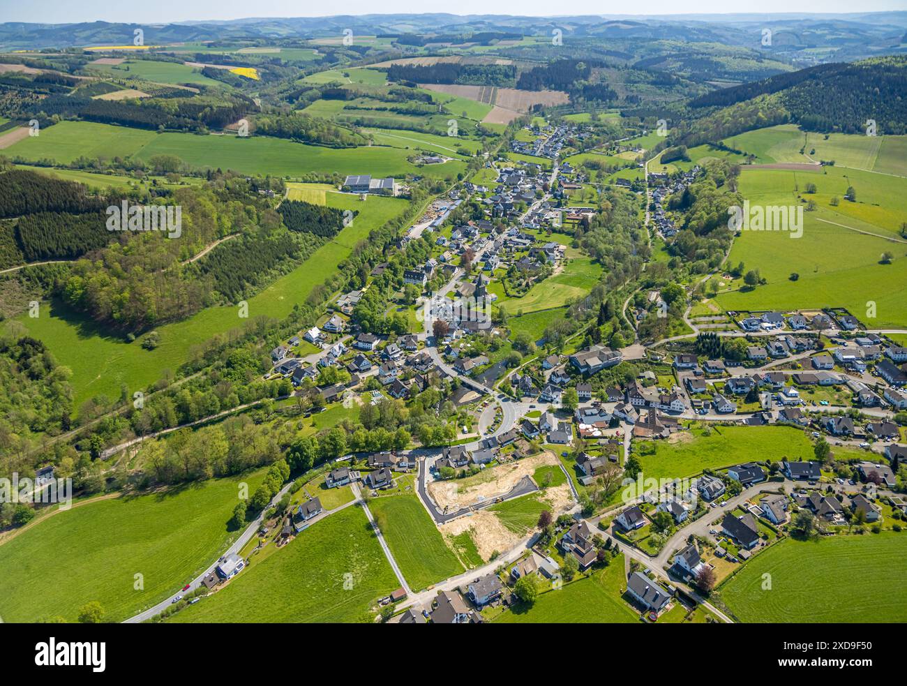 Vue aérienne, vue locale paysage vallonné de Wenholthausen, église catholique équipée Cäcilia et école primaire, quartier résidentiel avec chantier entre Banque D'Images