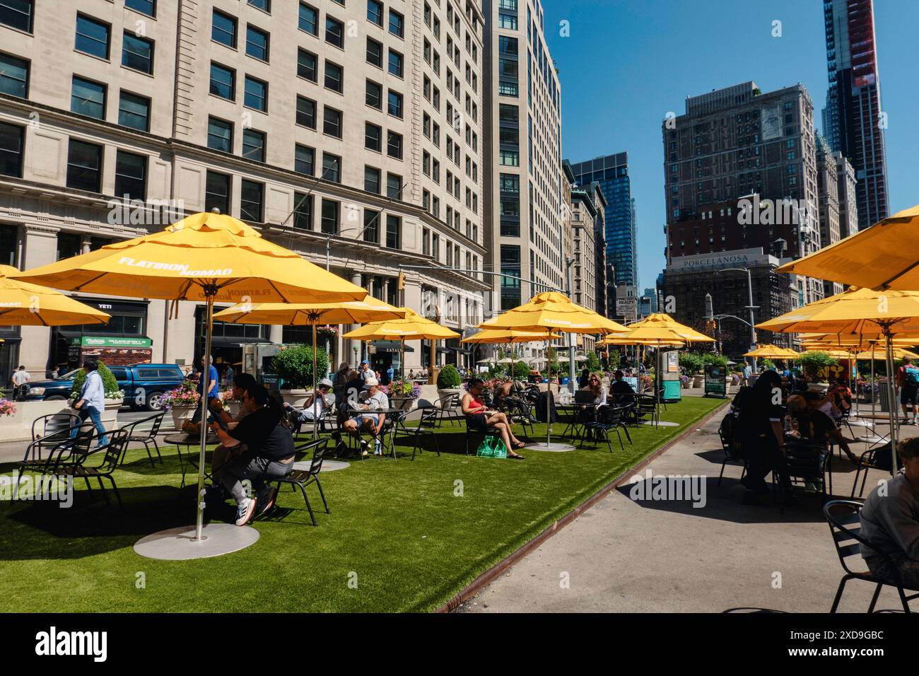 La zone de sièges publics à Fifth Avenue et 23rd équipés dispose de parapluies jaune vif pour l'ombre, 2024, New York City, Nomad, États-Unis Banque D'Images