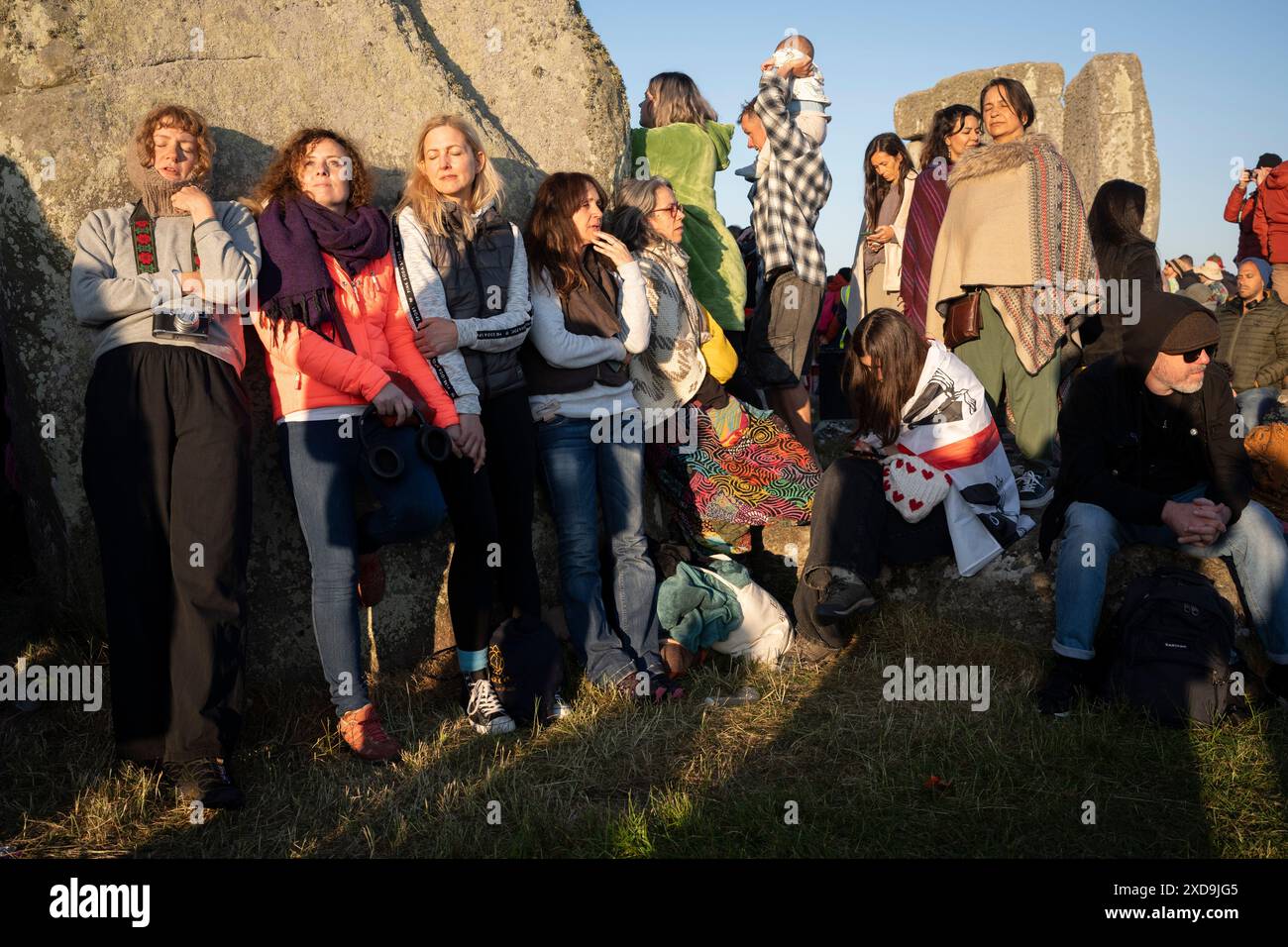 Les fêtards spirituels célèbrent le solstice d'été (mi-été et jour le plus long) parmi les anciennes pierres du néolithique tardif de Stonehenge, le 21 juin 2024, dans le Wiltshire, en Angleterre. Le solstice d'été est le jour le plus long de l'hémisphère nord et la nuit la plus courte de l'année, lorsque l'axe de la terre est incliné à son point le plus proche du soleil et les païens disent que l'ancien monument est un lieu sacré qui relie la Terre, la Lune, le Soleil et les saisons. Stonehenge a été construit en trois phases entre 3 000 av. J.-C. et 1 600 av. J.-C. Stonehenge appartient à English Heritage qui dit que 15 000 visiteurs ont été autorisés à entrer Banque D'Images