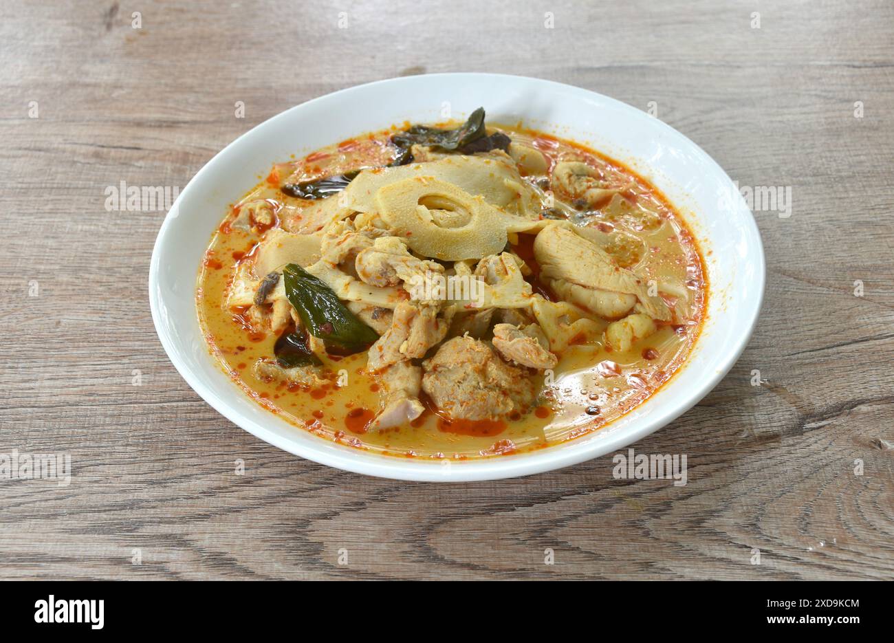 pousses de bambou marinées épicées en tranches bouillies avec poulet dans une soupe au curry au lait de coco sur une assiette Banque D'Images