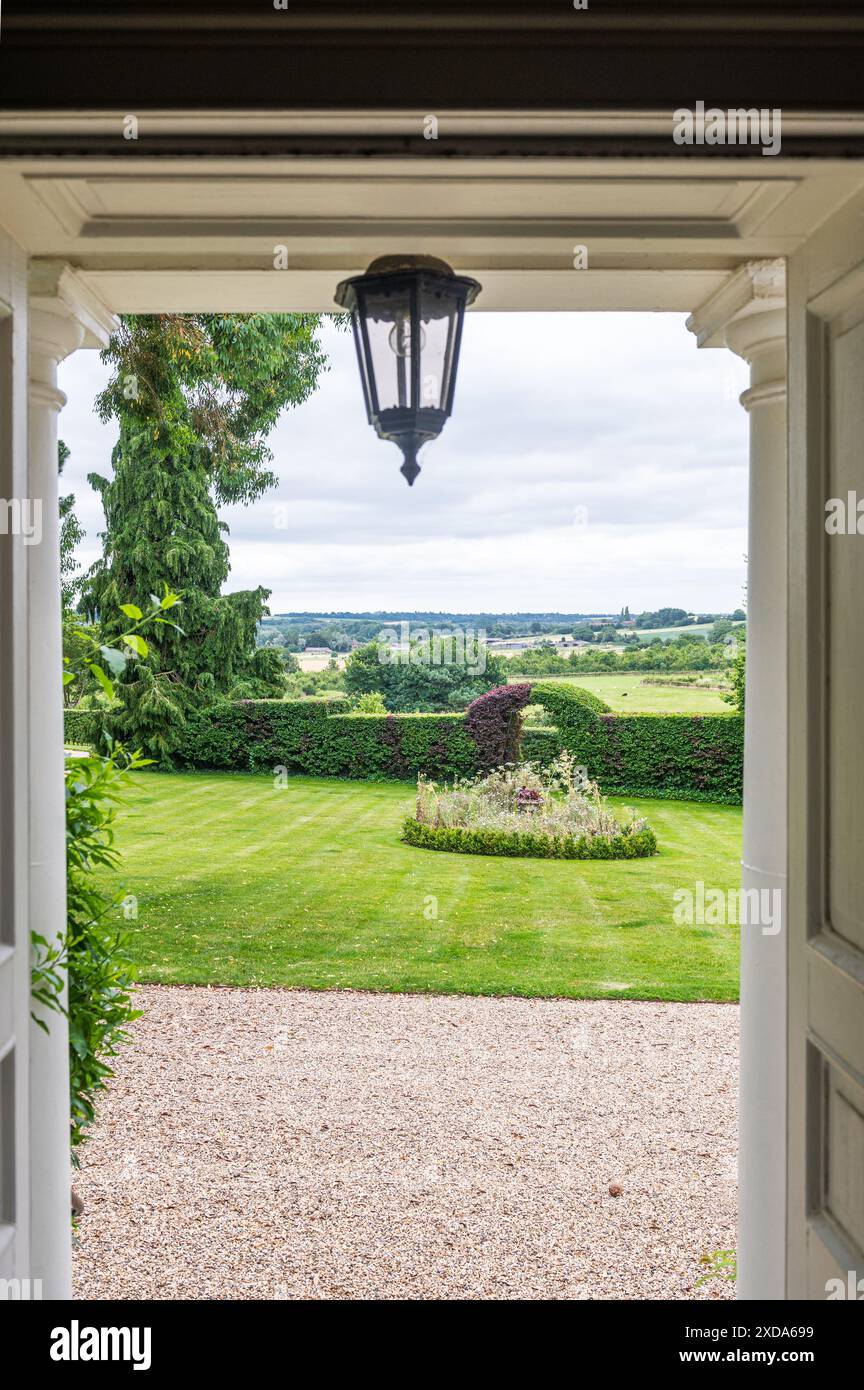 Vue à travers la porte au jardin de la maison de campagne du 16ème siècle, Suffolk, Angleterre, Royaume-Uni Banque D'Images