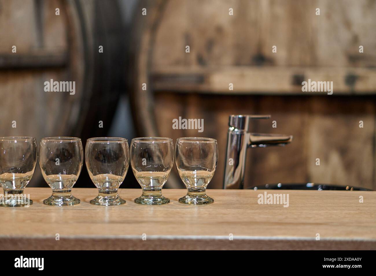 Verres vides à l'intérieur d'une cave à vin avec des tonneaux en arrière-plan en attente d'une visite de dégustation de vin à Cafayate, Salta, Argentine Banque D'Images