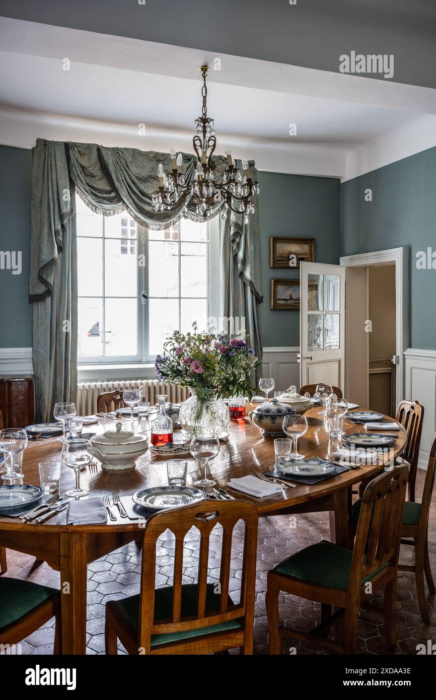 Salle à manger avec table dressée dans un hôtel particulier en pierre rénové datant de 1770 à Saulieu, Bourgogne, France. Banque D'Images