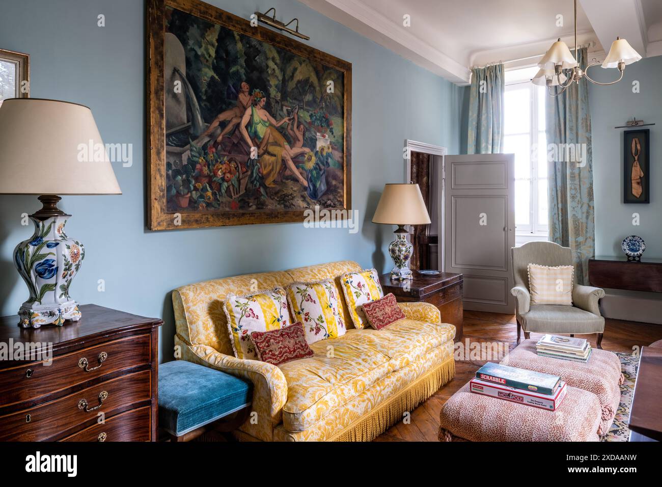 Canapé jaune et lampes avec œuvres d'art dans un hôtel particulier en pierre rénové datant de 1770 à Saulieu, Bourgogne, France. Banque D'Images