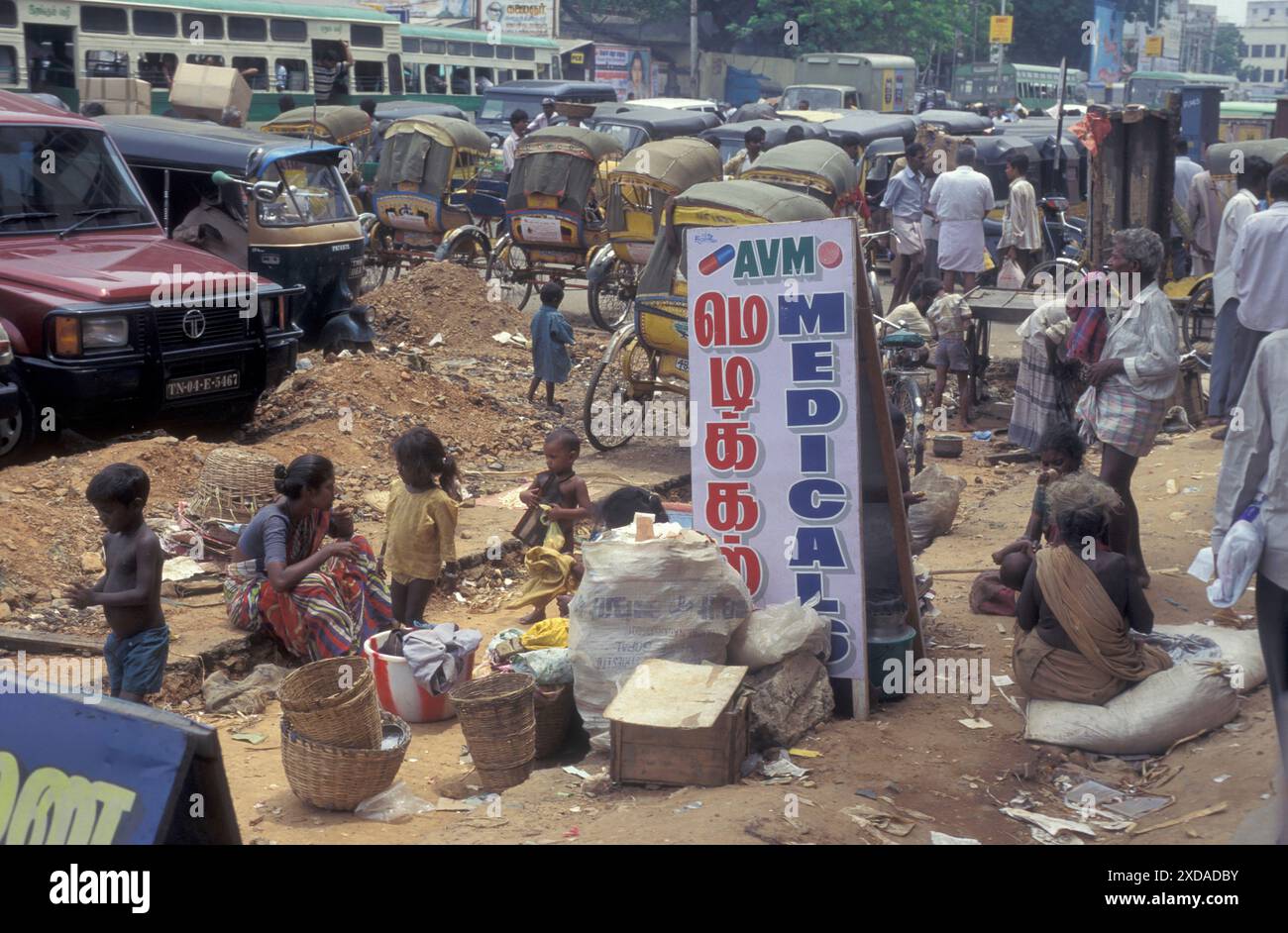 Des pauvres et des enfants avec de la nourriture devant un magasin médical sur une place dans la ville de Chennai dans la province du Tamil Nadu en Inde. Inde, Chenna Banque D'Images