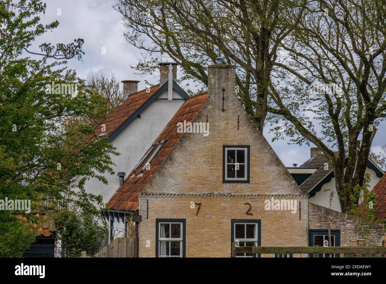 Une maison rustique avec un toit escarpé et des arbres en arrière-plan, nes, ameland, pays-bas Banque D'Images