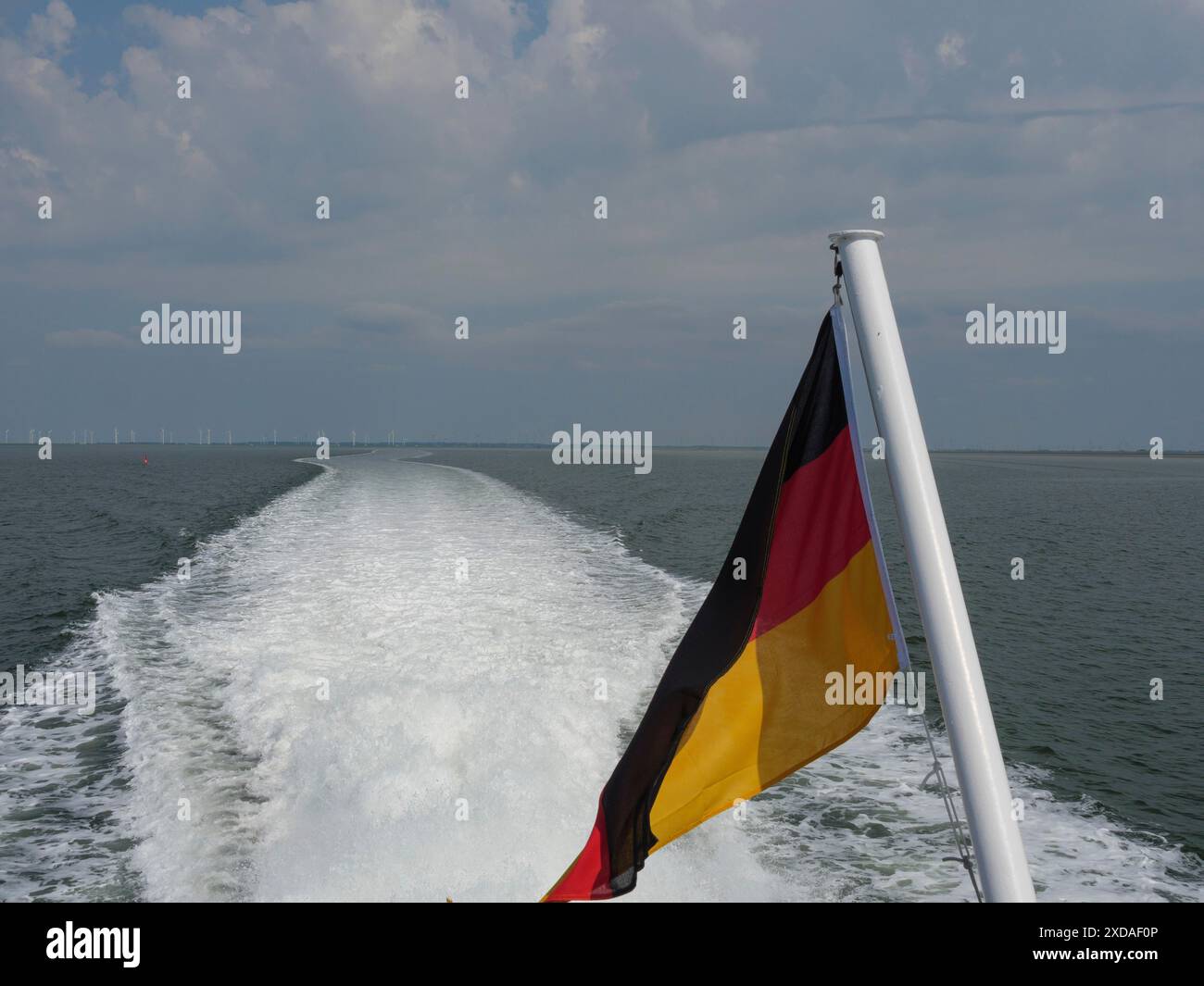 Vue du pavillon allemand sur un navire laissant des ondulations dans l'eau transmet un sentiment de liberté et de voyage, Hallog Hooge, schleswig-holstein, allemagne Banque D'Images