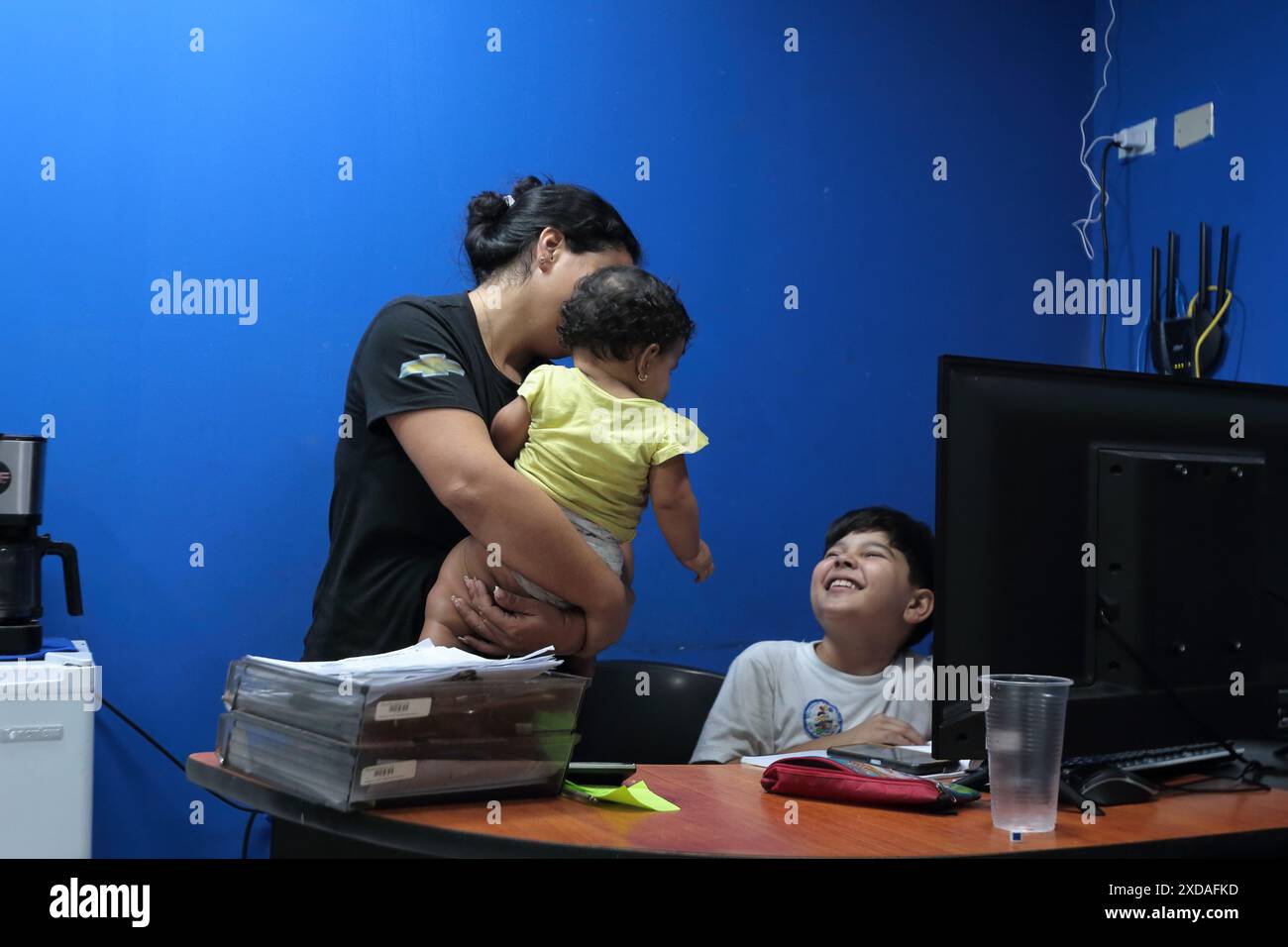 Maracaibo, Venezuela.5-14-2024. Alejandro Matias arrive à l’atelier de son père après l’école pour aider son père comme mécanicien. Photo de. Jose I. Bula Banque D'Images