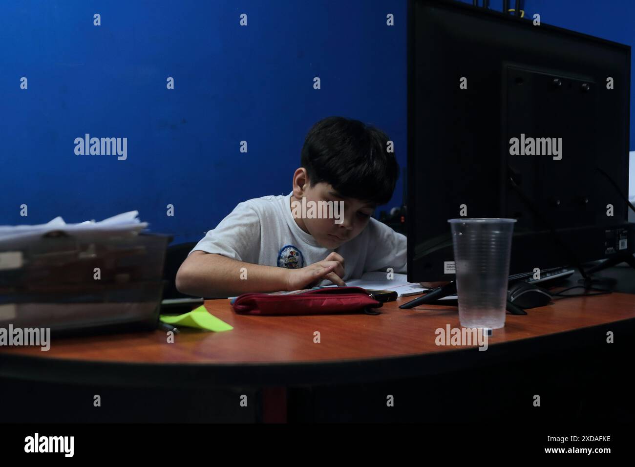 Maracaibo, Venezuela.5-14-2024. Alejandro Matias arrive à l’atelier de son père après l’école pour aider son père comme mécanicien. Photo de. Jose I. Bula Banque D'Images