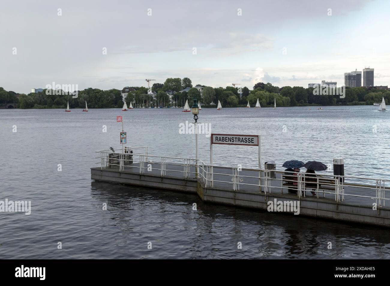 Image symbolique météo, activités de loisirs, fortes pluies en été, les gens avec des parasols sur la jetée Rabenstrasse devant le ciel sombre avec de la pluie Banque D'Images