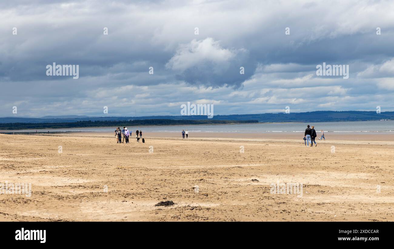 les gens marchant sur la plage pendant une journée ensoleillée Banque D'Images