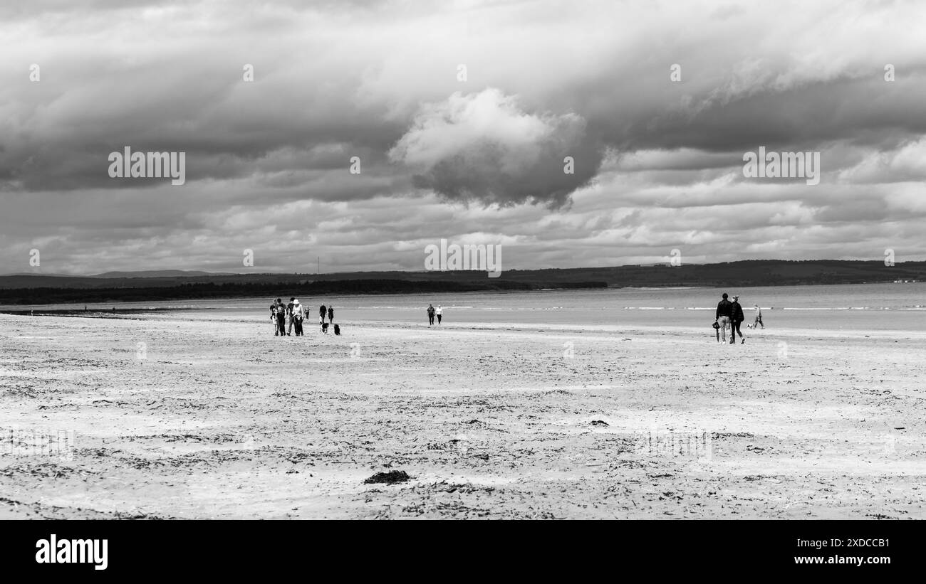 les gens marchant sur la plage pendant une journée ensoleillée Banque D'Images