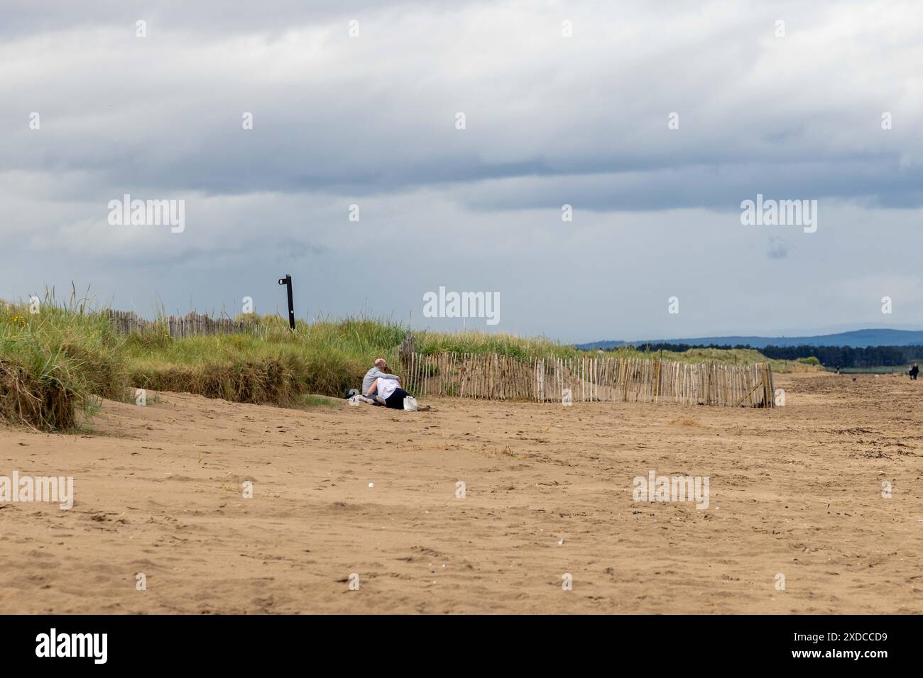 les gens marchant sur la plage pendant une journée ensoleillée Banque D'Images