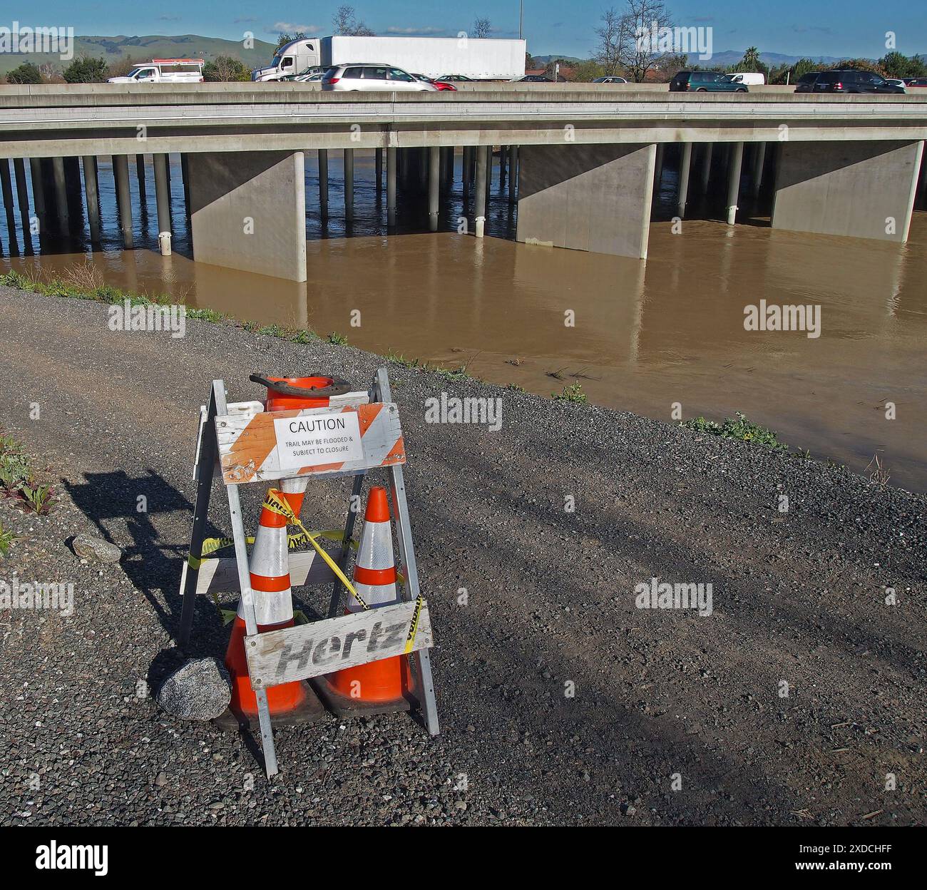 Le sentier de prudence peut-être inondé et sujet à un panneau de fermeture sur le sentier Alameda Creek après une tempête de fortes pluies, Californie Banque D'Images