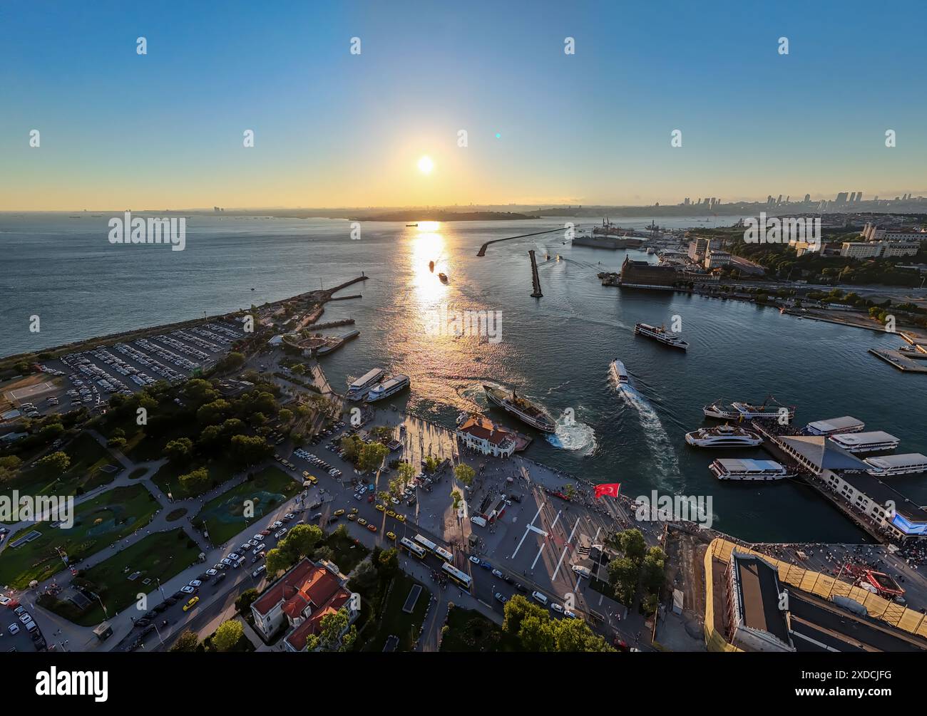 Coucher de soleil vue à vol d'oiseau depuis le tir de drone aérien de Kadikoy Port, Haydarpasa, harem et Bosphore en arrière-plan, rues, gens marchant des voitures Banque D'Images