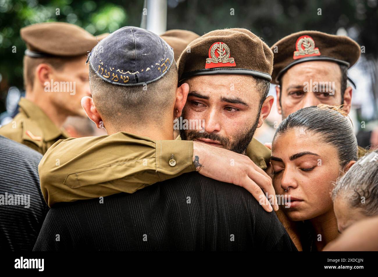 Un soldat israélien embrasse un ami lors de la cérémonie funèbre du soldat Omer Smadga, tombé au cimetière militaire de Netanya. Smadga est morte jeudi au combat avec le Hamas dans la bande de Gaza. Son père, Oren, a parlé par-dessus sa tombe et a appelé les FDI à continuer à se battre aussi dur que possible, 'je dis aux soldats ici de garder la tête haute. Continuez aussi dur que possible. N'arrête pas jusqu'à ce qu'on gagne. C'est mon message à quiconque au combat. AM Israel Hai. Oren Smadga est le médaillé olympique israélien en judo des Jeux Olympiques de Barcelone 1992 et l'entraîneur actuel de l'équipe israélienne de judo. Banque D'Images