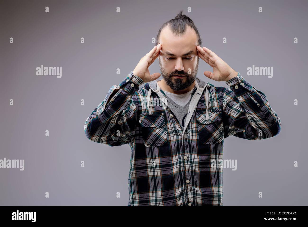 L'homme avec un mal de tête de tension masse ses tempes, montrant douleur et détresse Banque D'Images