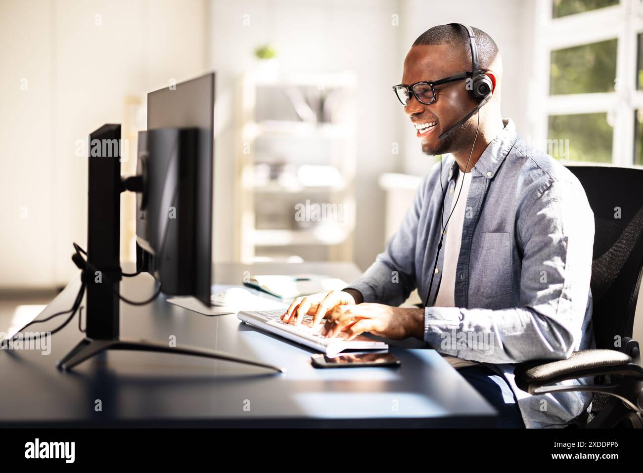 Service clientèle efficace : agent de centre d'appels souriant dans les bureaux occupés offrant un excellent service grâce au micro-casque/oreillette pour l'assistance commerciale Banque D'Images