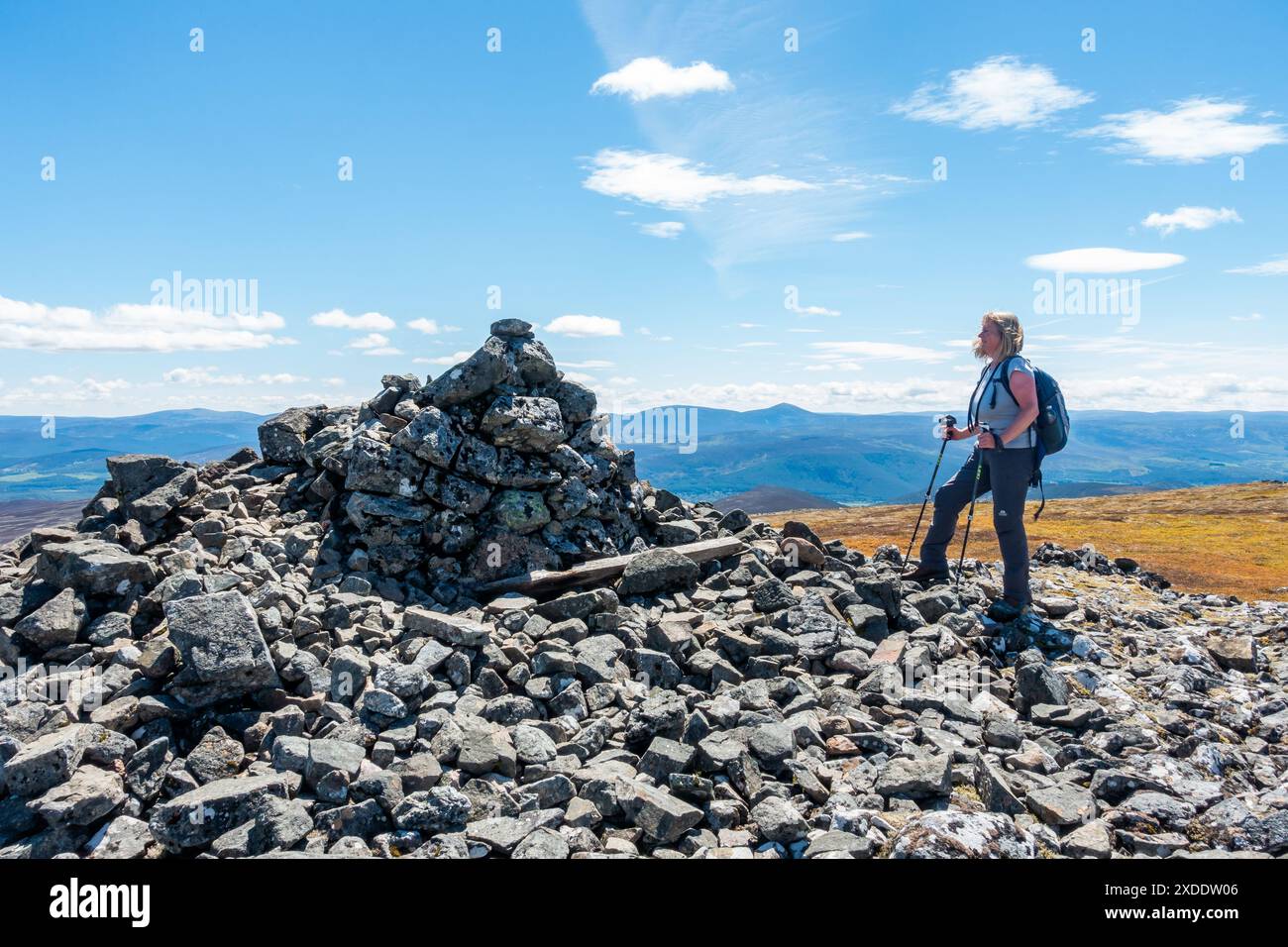 Un marcheur au sommet cairn sur la montagne Corbett de Morven près de Logie Coldstone, Aberdeenshire, Écosse. Le mont Keen est visible en arrière-plan Banque D'Images