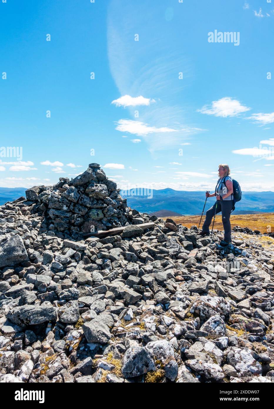 Un marcheur au sommet cairn sur la montagne Corbett de Morven près de Logie Coldstone, Aberdeenshire, Écosse. Le mont Keen est visible en arrière-plan Banque D'Images