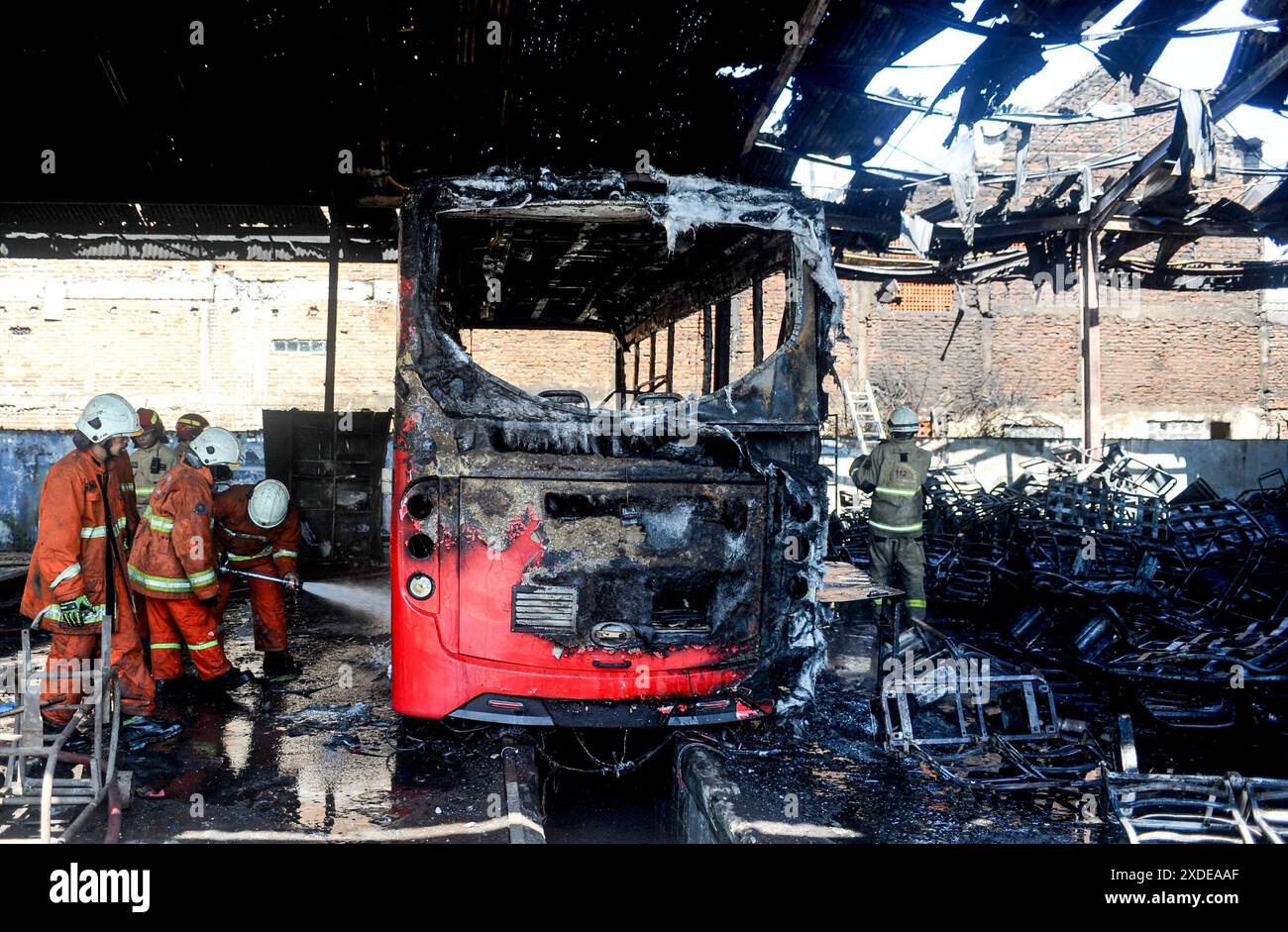 Surabaya, Indonésie. 22 juin 2024. Des pompiers tentent d'éteindre un incendie d'autobus dans un garage à Surabaya, Java oriental, Indonésie, le 22 juin 2024. Aucune victime n'a été signalée dans cet incendie. Crédit : Sahlan Kurniawan/Xinhua/Alamy Live News Banque D'Images