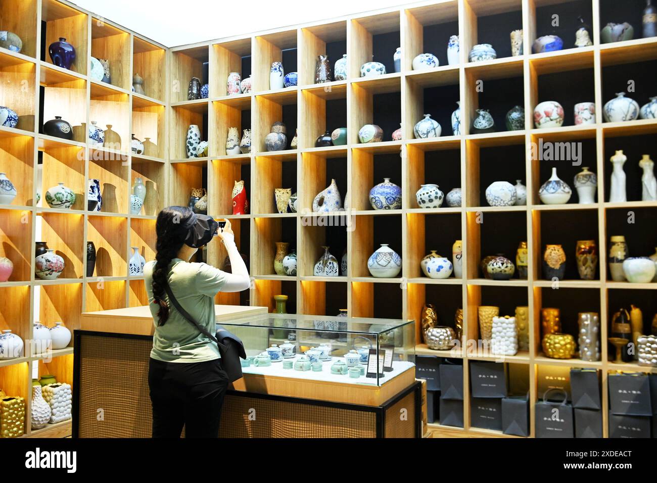 QINGDAO, CHINE - 21 JUIN 2024 - Un visiteur prend des photos de céramiques exposées à l'atelier de céramique Zhuzi dans la ville de Liuwang, dans le nouveau district de la côte ouest, Qin Banque D'Images