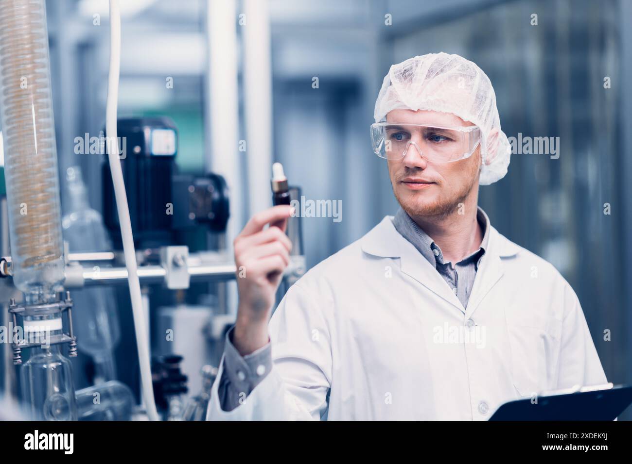 Scientifique dans Science Lab a fièrement inventé la nouvelle formule de médecine. Le personnel d'usine médicale souriant heureux avec l'extrait médical concentré de l'usine. Banque D'Images