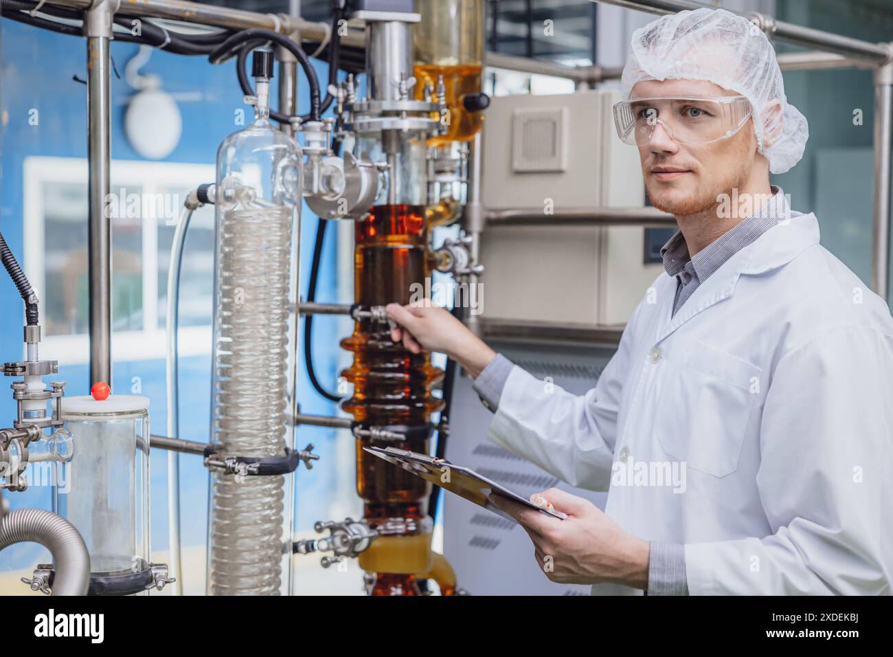 Scientifique travaillant avec des équipements dans Science Lab. Personnel d'usine médicale extraction d'huile de cannabis CBD. Usine de distillation de film mince d'huile de chanvre processus. Banque D'Images Scientifique travaillant avec des équipements dans Science Lab. Personnel d'usine médicale extraction d'huile de cannabis CBD. Usine de distillation de film mince d'huile de chanvre processus. Banque D'Images