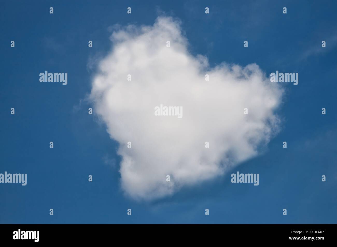 Nuage en forme de coeur dans un ciel bleu vif. Banque D'Images